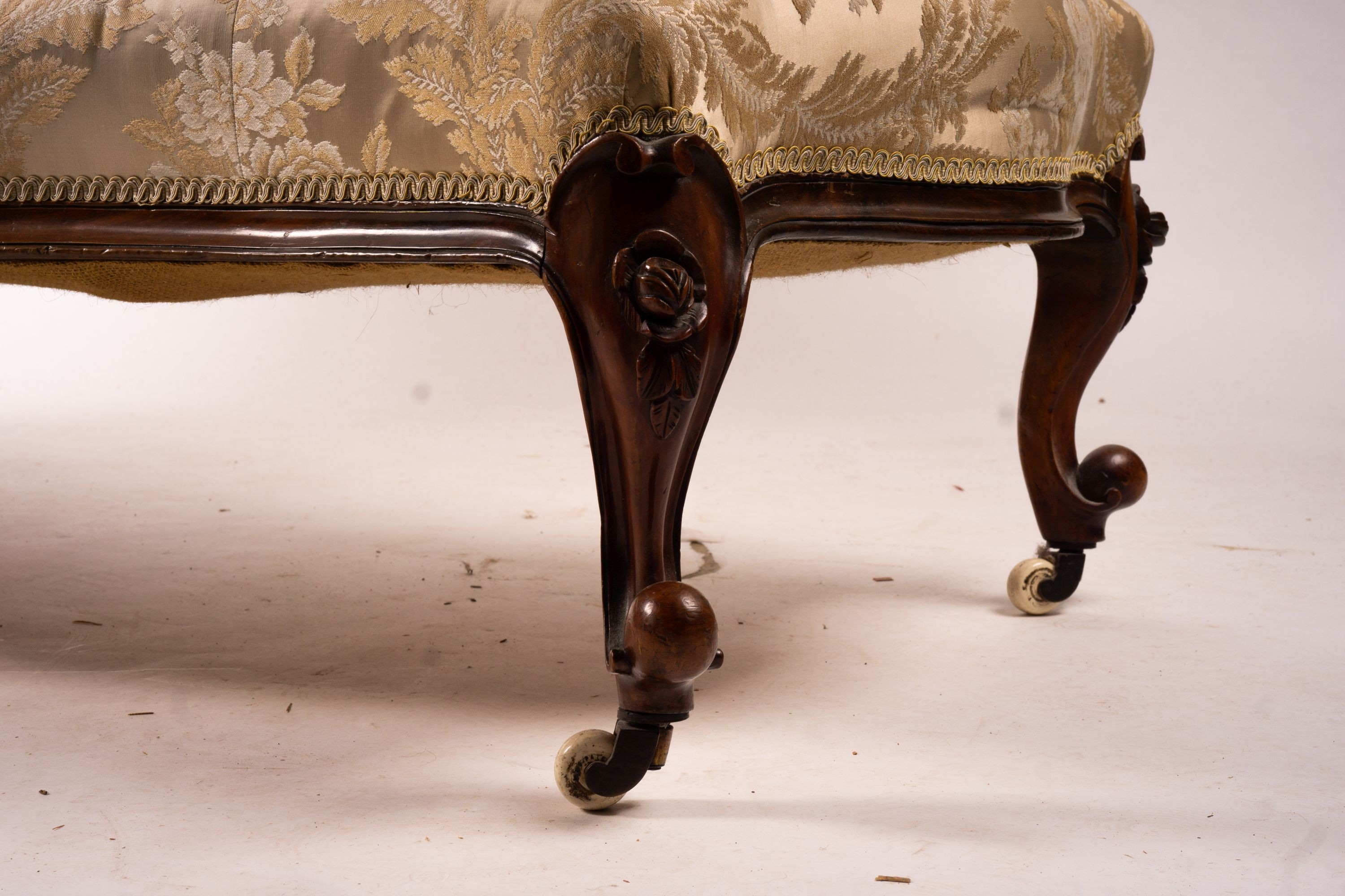 A late Victorian carved walnut three piece salon suite, comprising chaise longue, open armchair and nursing chair